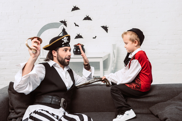 father and son in pirate costumes playing at home, halloween holiday concept - Fotoğraf, Görsel