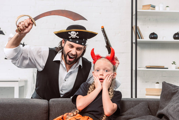 portrait of daughter and father in halloween costumes playing at home - Fotografie, Obrázek