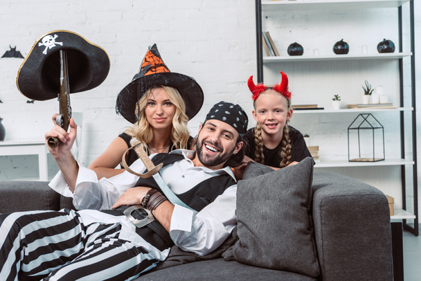 portrait of smiling family in halloween costumes at home - Foto, imagen