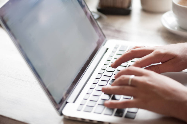 Jonge blonde vrouw freelancer te typen in de laptop in café - Foto, afbeelding