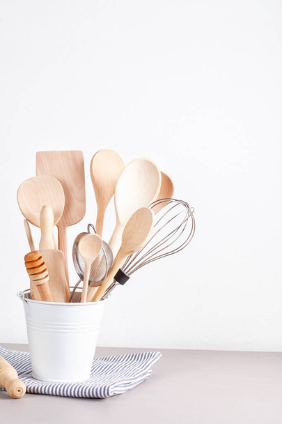 Various kitchen utensil in metallic basket on grey table with napkin. - Photo, Image