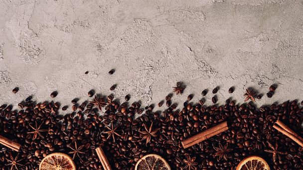 top view of spilled coffee beans with dry spices on concrete surface - Valokuva, kuva
