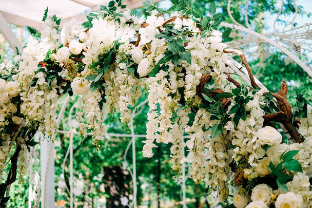 Preparándose para la ceremonia de boda. Arco de boda decorado con flores blancas
 - Foto, imagen