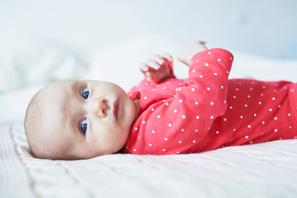 Adorable baby girl lying on bed. Infant kid in sunny nursery - Foto, immagini