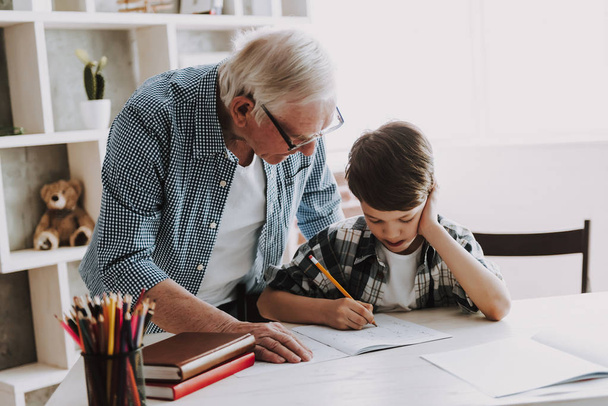 Grandson Doing School Homework with Old Man Home. Family Relationship Between Grandfather and Grandson. Grandpa Teaching, Male Grandchild, Learning Concept. Relations and People Concept. - Fotoğraf, Görsel