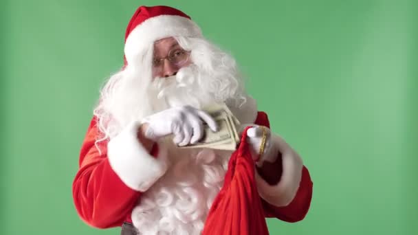 Santa Claus takes a pile of bills from a red bag, money concept green chromakey in the background. - Felvétel, videó