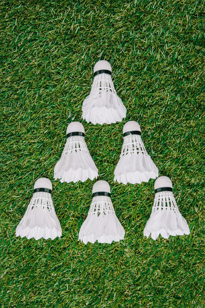 Widok góry białe lotki do badmintona, ułożone na zielony trawnik - Zdjęcie, obraz