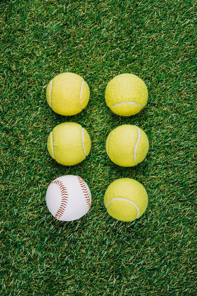 flat lay with arrangement of tennis and baseball balls on green grass - Foto, afbeelding