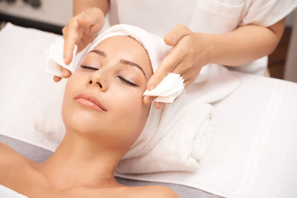Beautician taking off excess of serum from face of client, spa procedure - Foto, immagini