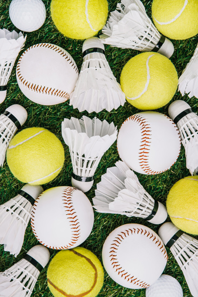 vista superior de disposición de pollas de transporte de bádminton, pelotas de tenis y béisbol en césped verde
 - Foto, imagen