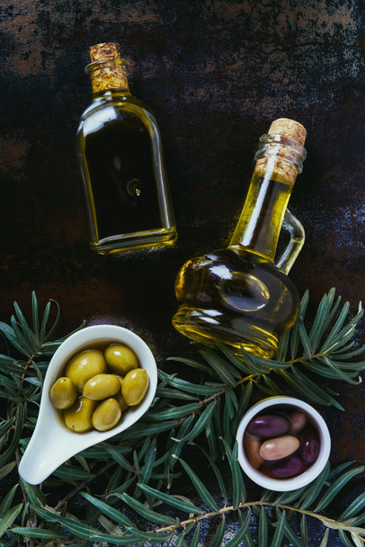 top view of two bottles of homemade olive oil and olives on shabby surface - Fotografie, Obrázek