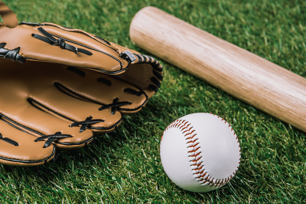 close up view of baseball equipment arranged on green grass - Photo, Image