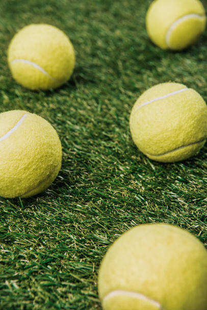 close up view of tennis balls on green lawn - Фото, изображение