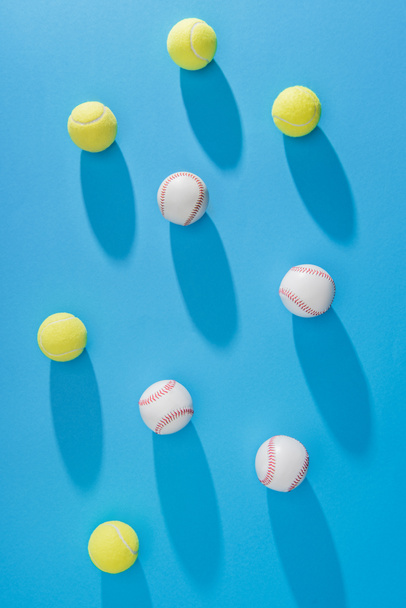 top view of arranged tennis and baseball balls on blue backdrop - Photo, Image