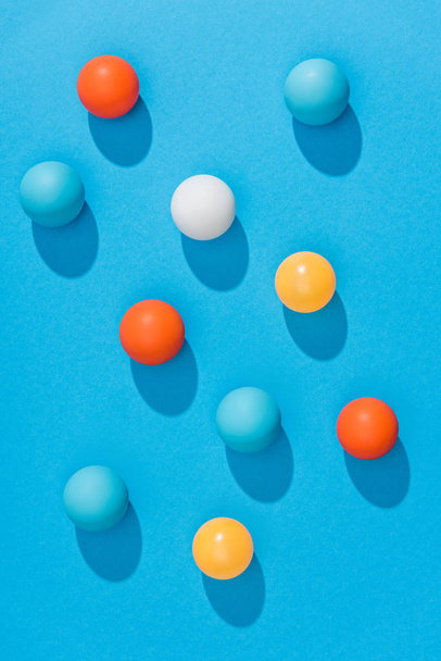 Widok z góry ułożone kolorowe pin ponga kulki na niebieskim tle - Zdjęcie, obraz