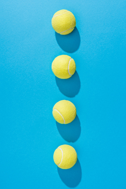 top view of arranged tennis balls on blue background - Photo, Image