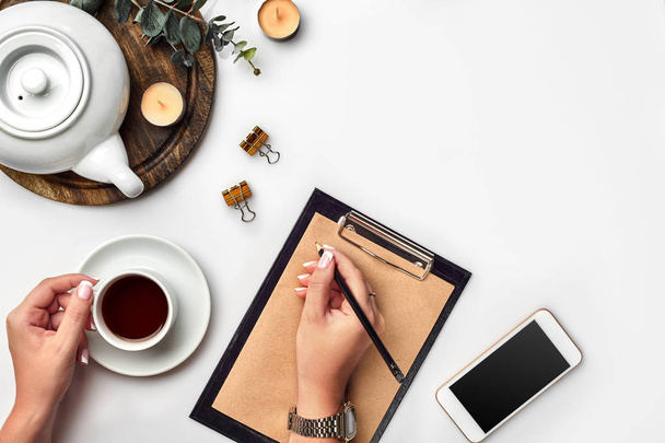 A woman hands writing on empty book note, diary, spread mockup, top view, studio. Cup of coffee break. - Photo, Image