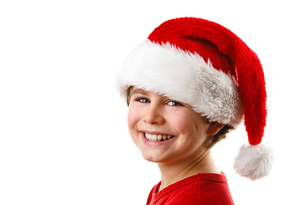 Cute boy in Santa hat smiling isolated on white background - Zdjęcie, obraz