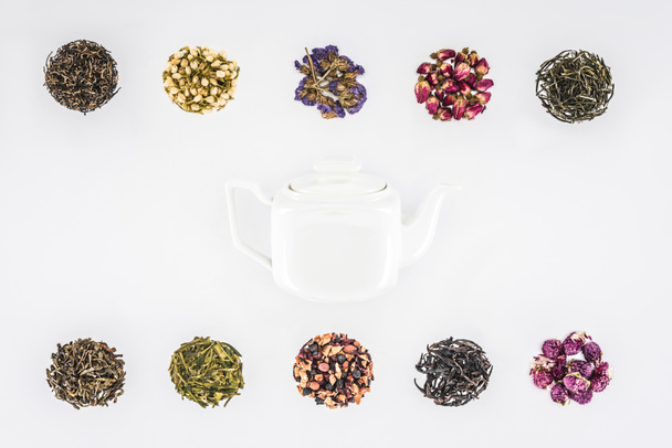 top view of dried herbal organic tea and glass teapot isolated on white - Фото, зображення