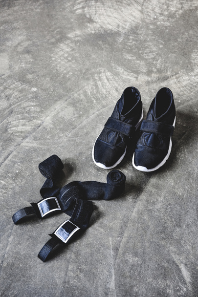 sneakers and wrist wraps on concrete surface - Foto, Imagem