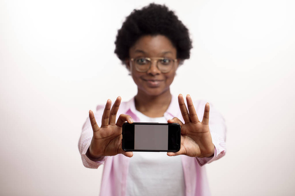 african awesome woman showing a new model of a smartphone - Φωτογραφία, εικόνα