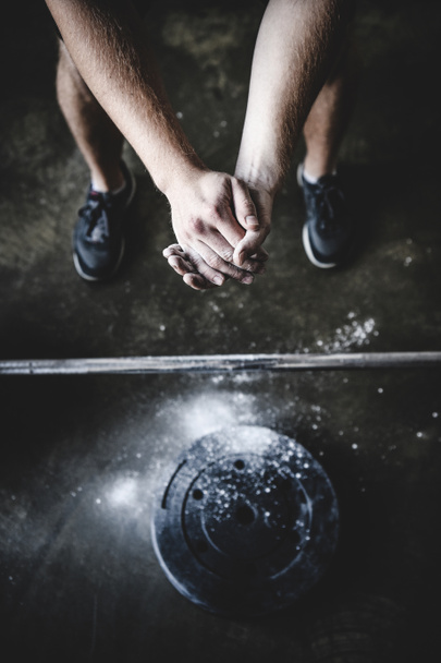 обрезанный снимок силового лифтера, закрывающего руки в тальке перед тренировкой
 - Фото, изображение