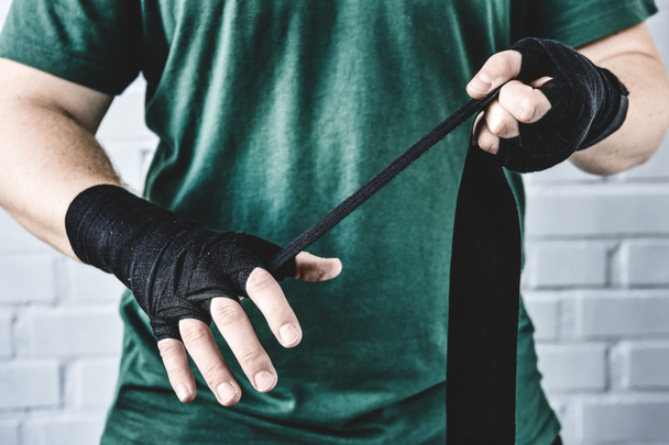 recortado tiro de levantador de pesas envolver las manos antes del entrenamiento
 - Foto, Imagen
