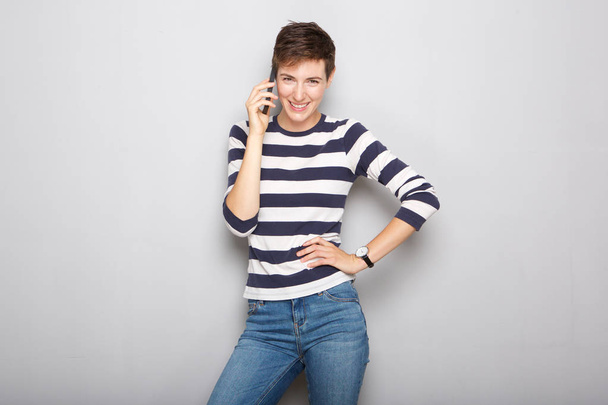 Portrait of young woman talking on cellphone and laughing - Photo, Image