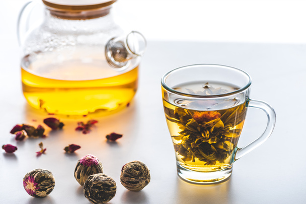 cup of chinese flowering tea with tea balls on white tabletop - Valokuva, kuva