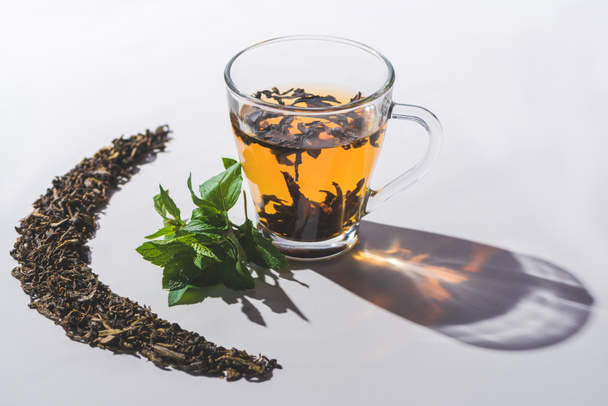 tasse de thé noir et menthe sur table blanche
  - Photo, image
