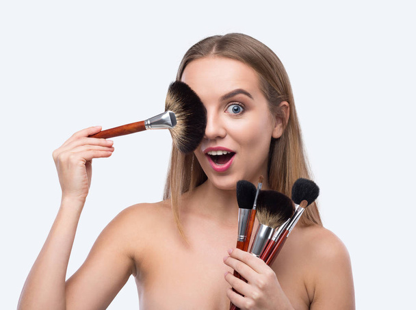 Gelukkige vrouw met make-up geborsteld geïsoleerd op wit - Foto, afbeelding