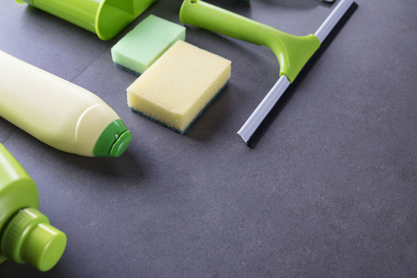 House and office cleaning up theme.  Set of colorful cleaning products on gray tiles.  background. Top view.  Place for logo, text or typography. - Photo, Image