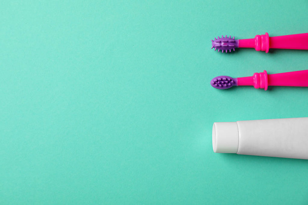 Baby toothbrushes and toothpaste with space for text on color background, top view - Fotoğraf, Görsel