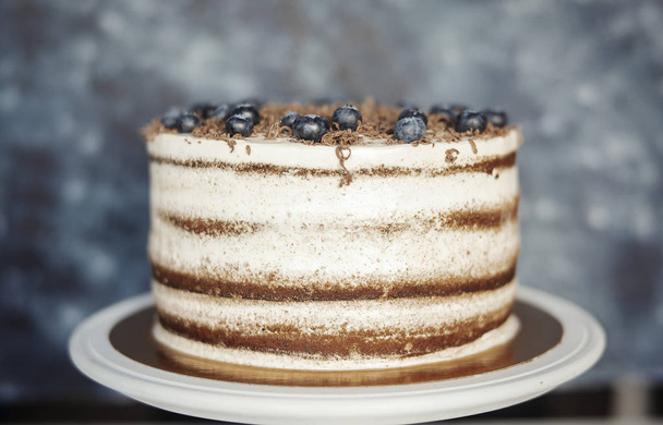 Close up of chocolate cake with cream cheese and berries on dark background. - Foto, Bild