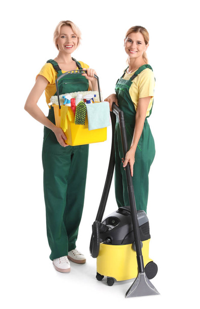 Female janitors with cleaning equipment on white background - Foto, Imagem