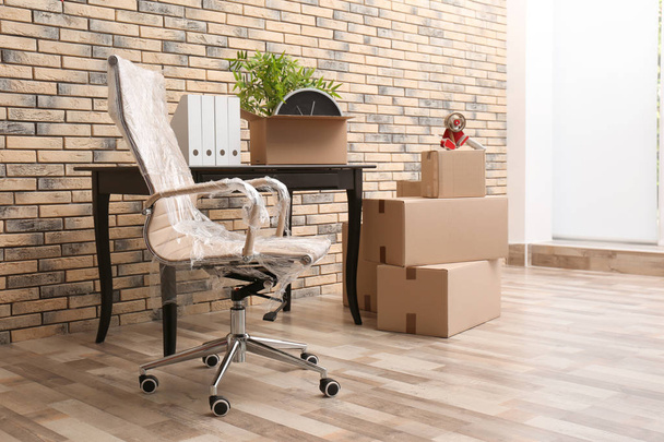 Furniture and moving boxes in empty office - 写真・画像