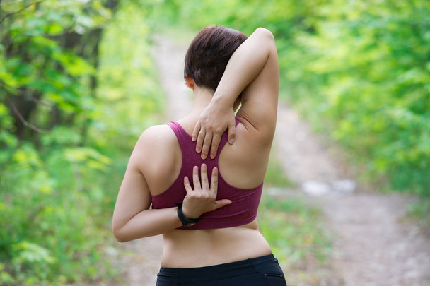 Woman with back pain, injury while running, trauma during workout, outdoors concept - Photo, Image