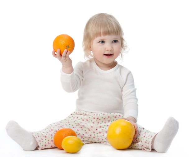 Happy baby with tasty fruits - Foto, afbeelding