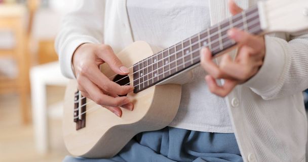 Nő játszani egy dalt ukulele - Fotó, kép