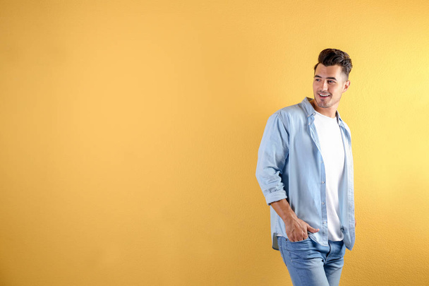 Young man in stylish jeans on color background with space for text - Φωτογραφία, εικόνα