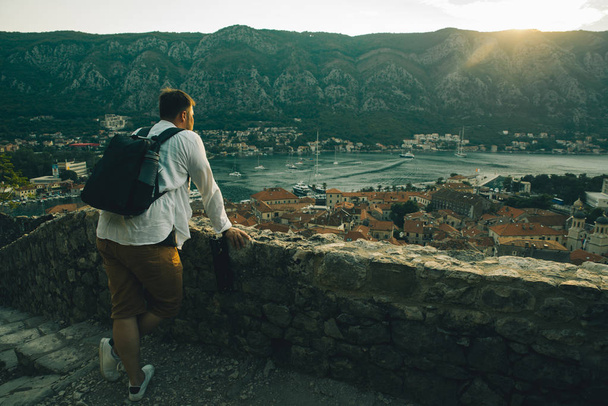 uomo in piedi e guardando il tramonto sulla città di Kotor a montenegro
 - Foto, immagini