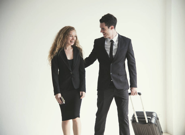 Young businesswoman and businessman with luggage talking in room airport. concept business travel trip. - Foto, immagini
