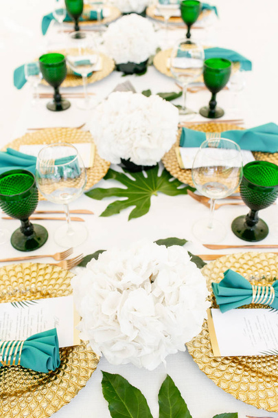 Belső sátor, esküvői vacsora, készen áll a vendégek részére. Szolgált kerek asztal kültéri díszített sátor Hortenzia virágok, a arany ételeket és a zöld szalvéta. Vendéglátóipari koncepció - Fotó, kép