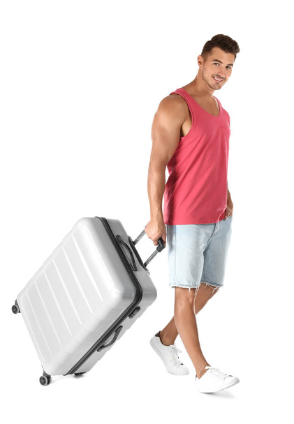 Young man walking with suitcase on white background - Zdjęcie, obraz