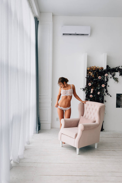 A girl with a beautiful figure in a stylishly decorated apartment - Foto, Imagen