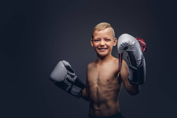 Radostné košili boy boxer v Boxerské rukavice je držitelem zlaté medaile pózuje ve studiu. Na tmavém pozadí, samostatný. - Fotografie, Obrázek