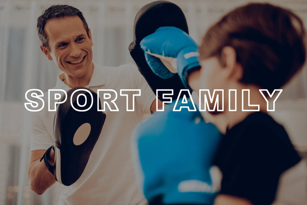 Father And Son Boxing Training. Sports Family. Healthy Lifestyle. Active Holiday. Gym Clothes. Working Out At Home. Kid With Boxing Gloves. Punch Training. Repeat Exercises. Right Handed Hook. - Foto, imagen