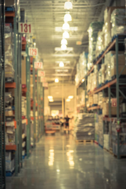 Vintage tone blurred image row of aisles, bins and shelves from floor to ceiling with flatbed cart in large warehouse. Defocused background industrial distribution storehouse interior hypermarket - Photo, Image