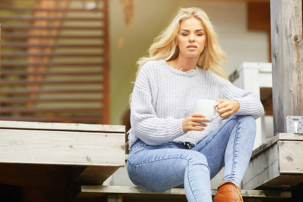 Woman drinking coffee at terrace on a sunny morning - Fotoğraf, Görsel