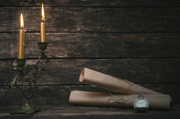 Wrapped scroll paper pages in the light of burning candle. The old letter. Writer or author concept. - Valokuva, kuva